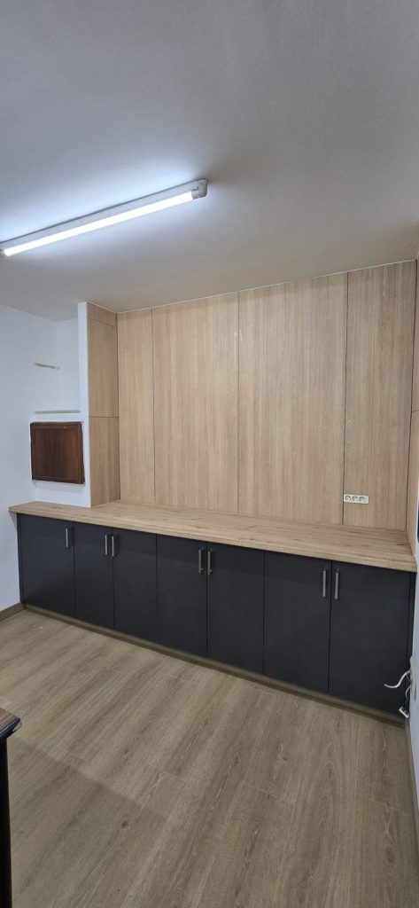 Mueble a medida con panel de madera y módulos bajos en gris antracita