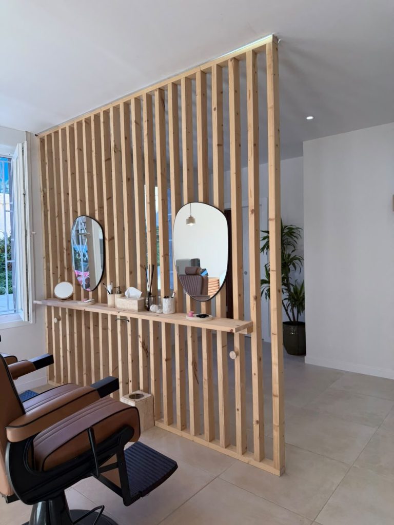 Separador de listones de madera y tocador a medida en un salón de belleza de Vigo, obra de Carpintería Coruxo